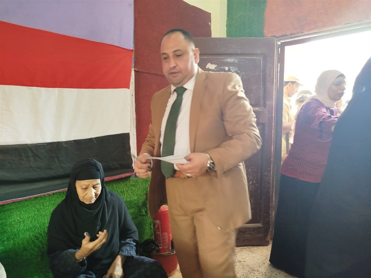 رئيس لجنة سيلا الابتدائية بالفيوم يساعد مسنّة على الإدلاء بصوتها